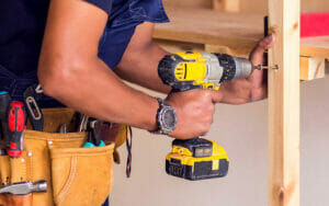 Man Drilling into Wooden Beam Learning How to Become a Handyman