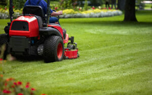 Man on red mower using Lawn Care Pricing Chart