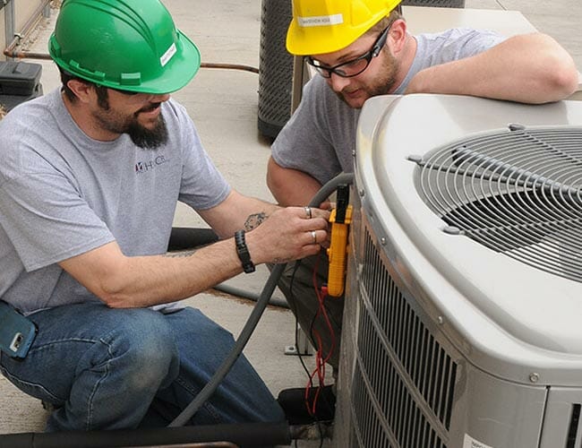 Two Techs Working On Hvac Unit 