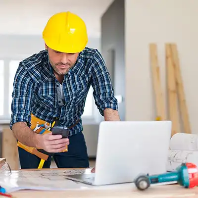 Man using contractor software on mobile phone at construction site