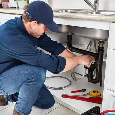 Plumbing software used by technician under a sink