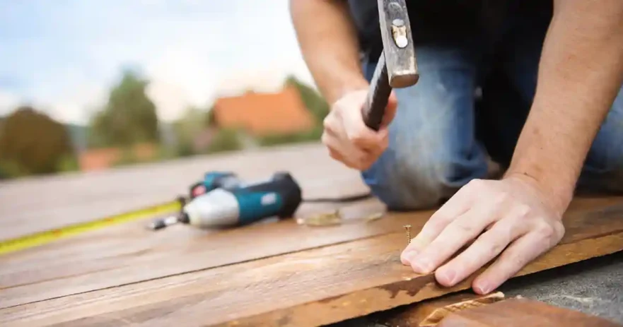 Handyman Hammering Nail into Wood